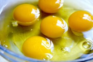 Foto: aufgeschlagene Eier in einer Schale